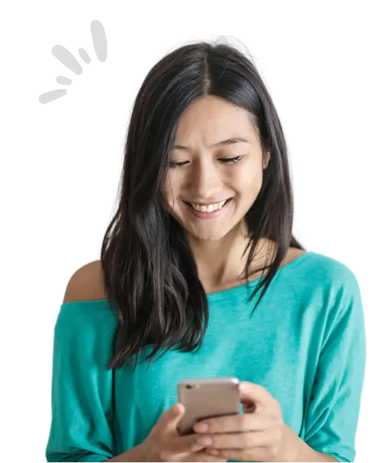 Jeune femme aux cheveux long brun, tenant son smartphone dans les mains, regardant l'écran avant un sourire