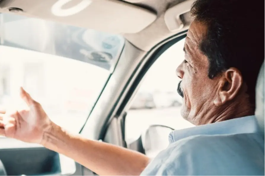 Inspecteur sur le siège passager discutant avec le conducteur au volant.