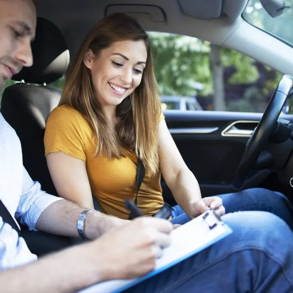 Instructeur expliquant les règles de conduite à une jeune femme dans une voiture